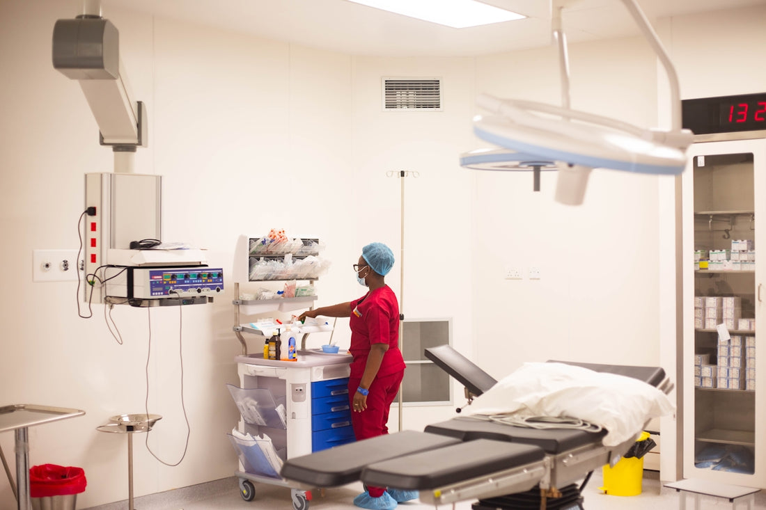 A nurse prepares instruments in an operating room.